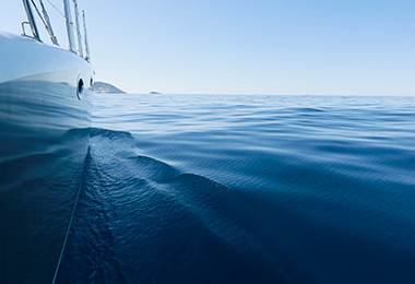 View from over the side of a boat of calm blue water