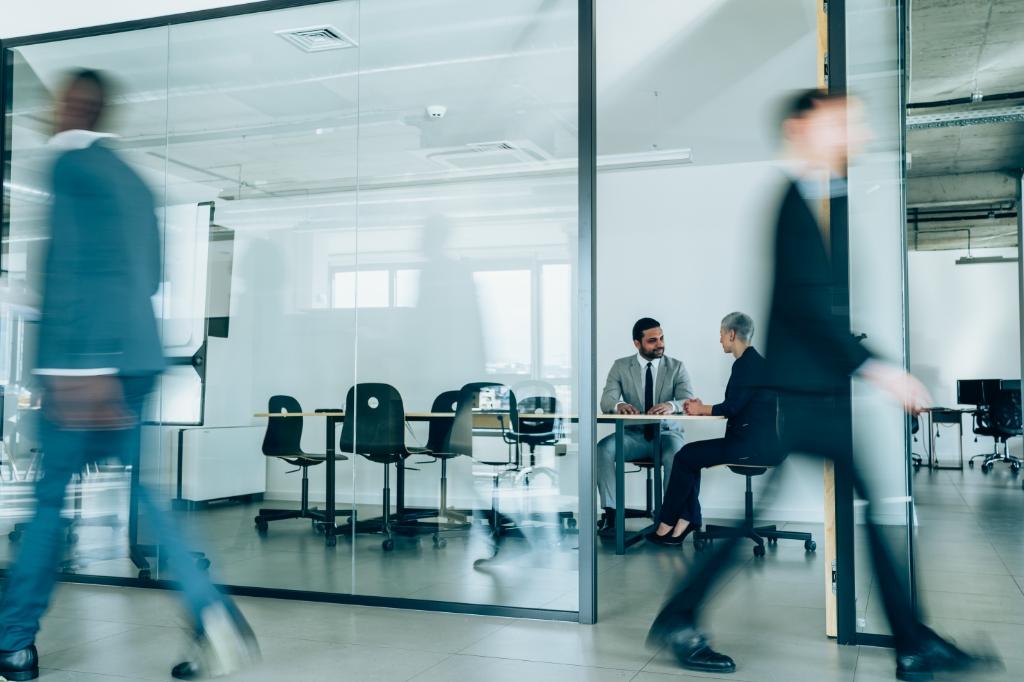 Financial professionals waking in hallway outside a conference room Financial professionals waking in hallway outside a conference room