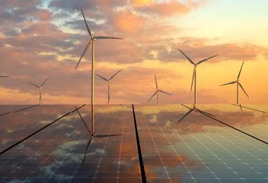 Solar panels and windmills at dusk